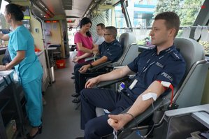 Na zdjęciu dwaj policjanci oddają krew w ambulansie
