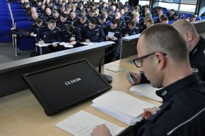 Na pierwszym planie zdjęcia członkowie komisji natomiast w tle policjanci rozwiązujący test