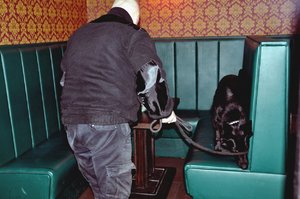 Na zdjęciu przewodnik z policyjnym psem, który przeszukuje pomieszczenie w nocnym klubie