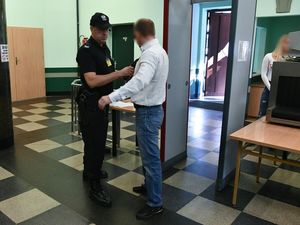 Policjanci obsługujący bramki wejściowe na salę sądową