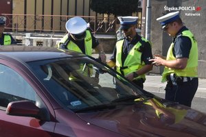 zdjęcie kolorowe: policjanci katowickiej drogówki podczas ogólnopolskich działań NURD w czasie kontroli samochodu