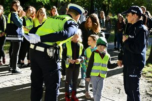 policjanci uczą dzieci z przedszkola jak bezpiecznie przechodzić przez jezdnię