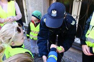 policjantka wręcza dzieciom odblaski