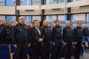 Zdjęcie kolorowe. Przedstawia Komendanta Wojewódzkiego Policji w Katowicach wraz z Zastępcami oraz innych uczestników odprawy rocznej