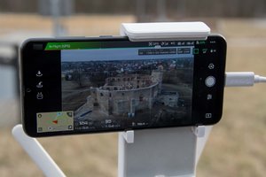 Zdjęcie kolorowe.  Widok ekranu telefonu, na którym wyświetlany jest obraz z kamery drona