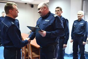 Generał wręcza tabliczkę pamiątkową policjantowi odchodzącemu na emeryturę
