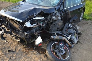 Zdjęcie z wypadku motocyklisty, który zderzył się z samochodem osobowym. Rozbite pojazdy.