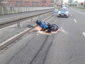 Rozbity motocykl, w tle radiowóz i policjant