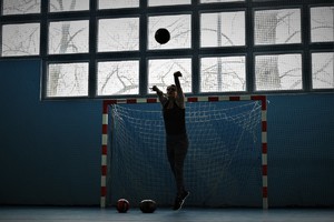 zdjęcie przedstawia osobę pokonującą tor przeszkód, rzucającą piłką