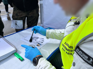 Na zdjęciu technik kryminalistyki pokazuje uczestnikom turnieju w jaki sposób zabezpiecza się ślady daktyloskopijne
