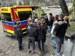 Na zdjęciu widać policyjny ambulans oraz grupę studentów.