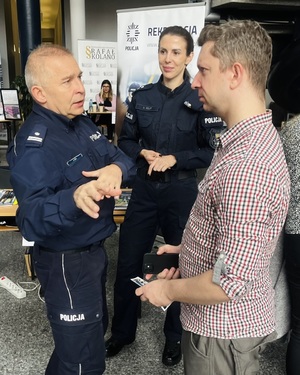 Na zdjęciu policjantka i policjant podczas rozmowy z mężczyzną.