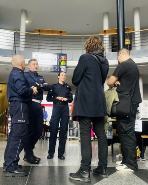 Na zdjęciu policjanci rozmawiają z mężczyznami.