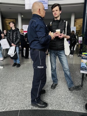 Na zdjęciu policjant rozmawia z mężczyzną.