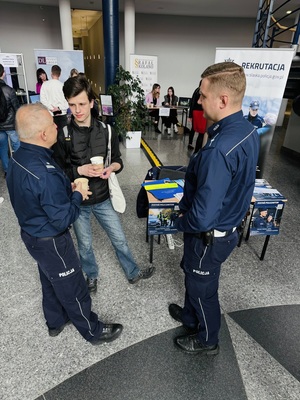 Na zdjęciu policjanci rozmawiają z mężczyzną.