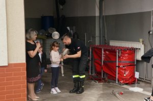 Strażak uczący grupę dzieci gaszenia pożaru