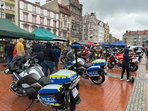 Na zdjęciu motocykle policji, motocykle i osoby zgromadzone na rynku.