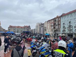 Na zdjęciu motocykle i osoby zgromadzone na rynku.