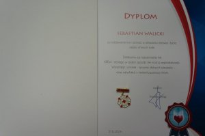 odznaka i dyplom wręczony mł. asp. Sebastianowi Walickiemu