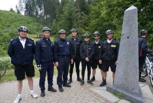 Wspólne zdjęcie policjantów z Czech, Polski i Słowacji obok specjalnego znaku granicznego na Trójstyku