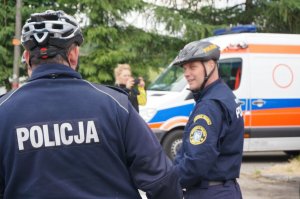 Polscy i słowaccy policjanci na tle ambulansu pogotowia ratunkowego