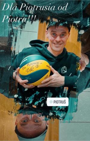 zdjęcie-skoczek narciarski Piotr Żyła trzyma piłkę z swoim autografem