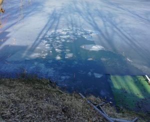 zdjęcie przedstawia popękany lód na zbiorniku wodnym