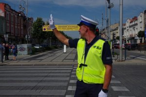 policjant w białej czapce podczas ręcznej regulacji na skrzyżowaniu