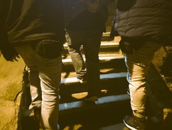 Dwóch policjantów prowadzi po scgodach zatrzymanego