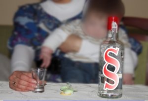 AWATAR- zdjęcie przedstawiające matkę z dzieckiem w towarzystwie alkoholu