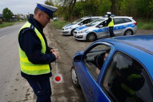 policjant kontroluje niebieski samochód