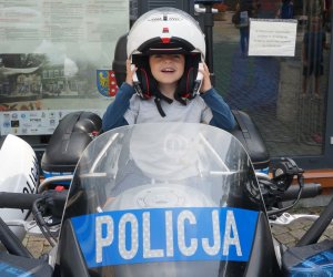 Na zdjęci dziecko na policyjnym motorze.
