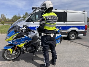 zdjęcie kolorowe: policjant katowickiej drogówki stojący przy motocyklu