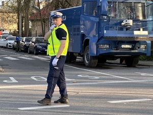 zdjęcie kolorowe: policjant drogówki kierujący ruchem na skrzyżowaniu