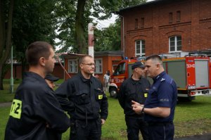 Młodszy inspektor Krzysztof Kazek z Policji rozmawia z mundurowymi ze straży pożarnej