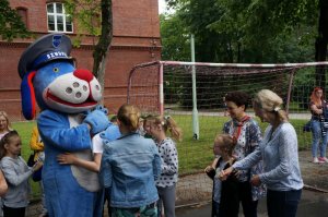 Maskotka śląskiej Policji ,,Sznupek&quot; w otoczeniu dzieci biorących udział w festynie