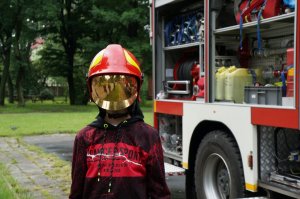 Chłopiec ubrany w hełm strażacki