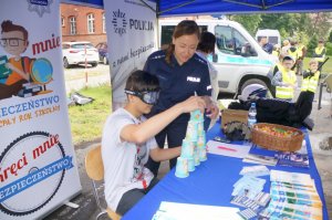 Aspirant Edyta Mazur z raciborskiej policji na stoisku opowiada dzieciom o bezpieczeństwie nad wodą i o prawach dziecka