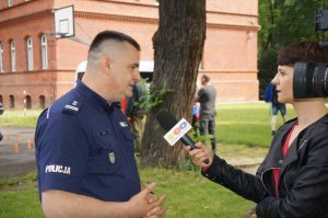 Przedstawiciel Komendy Wojewódzkiej Policji z Katowic podczas nagrania do raciborskiej telewizji opowiada cel spotkania mundurowych z dziećmi