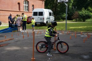 Kolejni uczniowi pokonują specjalny tor jazdy na rowerze pod nadzorem policjanta z raciborskiej drogówki