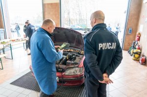 Policjanci i diagności w trakcie sprawdzania stanu technicznego samochodów