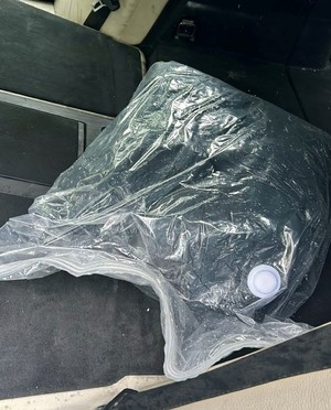 Zdjęcie przedstawia worek leżący we wnętrzu samochodu.