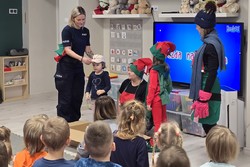 zdjęcie przedstawia policjantkę i pracowników przystani na prelekcji w przedszkolu