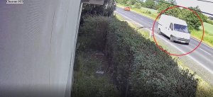 Na zdjęciu widać drogę, po której jedzie biały bus. Dla wyróżnienia auto zostało otoczone czerwonym kołem.