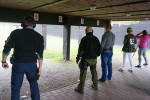 Pięciu zawodników stojących w rzędzie  przygotowuje się do strzału