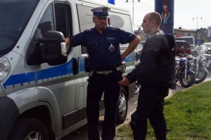 Policjant rozmawia z uczestnikiem parady motocyklistów