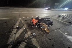 Na zdjęciu widać uszkodzony motocykl, drogę i przejeżdżające pojazdy.