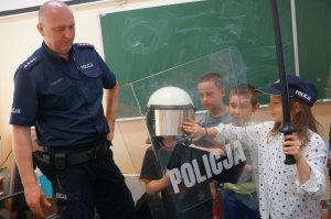policjant wraz z dziećmi w policyjnym sprzęcie