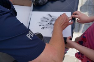 policjanci w czasie pobierania odcisków palców