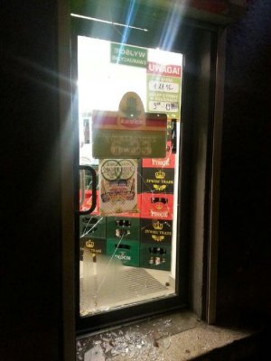 zdjęcie przedstawiające drzwi sklepu z wybitą szybą